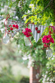 Wimpelkette dekoriert mit Rosensträußchen und Erdbeerzweigen in Glasvasen