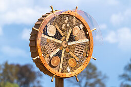 Insect hotel in the shape of a steering wheel at the edge of a rape field