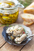 Pickled oysters in olive oil with herbs and spices