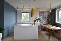 Kitchen with center island and dining area with floral wallpaper