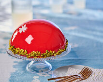 Mousse-Torte mit roter Spiegelglasur und Pistazien