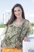 A young woman wearing a colorful, airy summer blouse