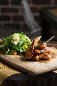 Grilled chicken with rocket salad on a wooden board