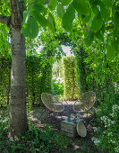 Idyllischer Sitzplatz unter Bäumen im Garten