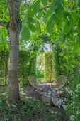 Idyllischer Sitzplatz unter Bäumen im Garten