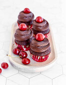 Schokoladen-Cupcakes mit Schokoladenganache und Kirschen