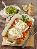 Fish fillets with mustard sauce on sliced carrots
