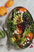 Avocado and spinach salad with blueberries, persimmon, and feta cheese