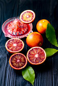 Blood oranges, whole and halved with juicer and reamer