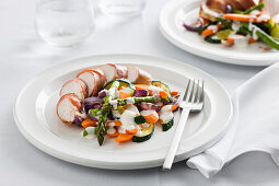 Chicken breast wrapped in pancetta served with mixed vegetables in a cream sauce