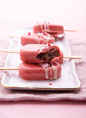 Vegan cakesicles covered in pink rice milk chocolate