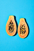 Halved papaya on a blue background