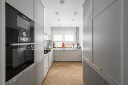 Modern grey kitchen with stone worktop and fluted cupboard fronts