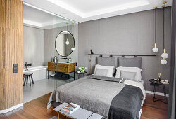 Bedroom in grey, view through glass door into a bathroom