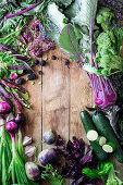 Green and purple vegetables creating a picture border with copy space