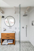 Loft bathroom with patterned tiled floor, shower cubicle, and vanity unit with countertop basin