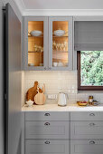 White and grey kitchen with illuminated cabinet