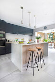 Fitted kitchen with dark fronts and kitchen island in open-plan living room