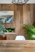 Dining area in front of oak plank wall paneling