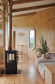 Bright sitting area with sofa and wood stove in front of the window