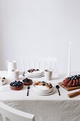 Breakfast table with yogurt bowls, berries and chocolate cake