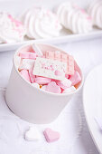 Weißer Becher mit rosa und weißen Zuckerherzen