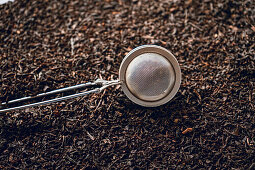 Metal tea strainer on black tea
