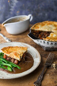 Steak und Ale Pie serviert mit Soße und Gemüse