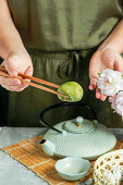 Making mochi (Japanese dessert) with matcha powder and cherries