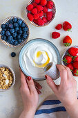 Griechischer Joghurt mit Ahornsirup, Himbeeren, Erdbeeren, Heidelbeeren und Müsli