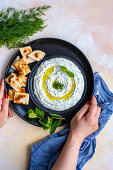 Turkish haydari meze dip topped with fresh mint leaves and olive oil and pita bread