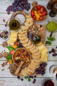 Vorspeisenbrett mit Brot, Käse, Nüssen, Olivenöl, Tomaten und Trauben