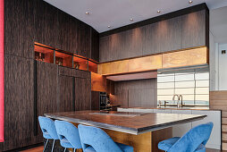 Maßgefertigte Küche mit Holzfront, Esstisch und blau gepolsterte Stühle