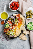 Loaded hummus platter with feta, tomatoes, cucumber, olives and onions