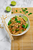Vegetarian Pad Thai with flat rice noodles, smoked tofu, egg, peanut butter and lime