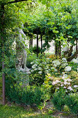 Statue and snowball hydrangea in the garden