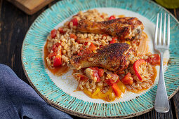 Chicken drumsticks baked with barley, tomatoes and peppers