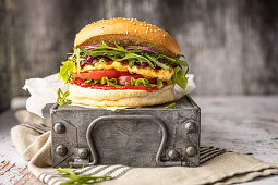 Vegetarischer Burger mit Halloumi, Cranberry-Marmelade, Rucola-Salat und roten Zwiebeln