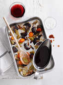 Rich wine sauce with pan of roasted vegetables