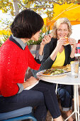 Two girlfriends eating outside