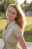 Blonde woman in light blouse dress outside