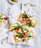Goat's cheese tarts with green asparagus, garlic and tomatoes