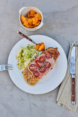 Paniertes Schnitzel mit Schinken ud Tomaten, dazu Lauchsalat und Süßkartoffel