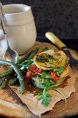 Stacked potato slices with mixed vegetables and basil pesto