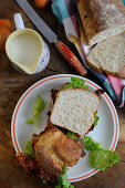 Sandwich aus hausgemachtem Brot mit Speck, Salat und Tomaten