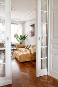 View through open sliding glass doors into the old-style living room with comfortable sofa and arc lamp