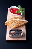 Sardines in oil, toasted bread and tomatoes with basil