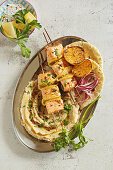 Spicy citrus salmon skewers with white bean puree