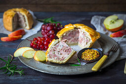 British pork pie with grainy mustard, apple slices, and red grapes