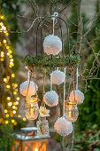 Weihnachtsdeko im Garten mit Schneeballkugeln aus Wolle und Kerzen als Mobile, an Adventskranz hängend